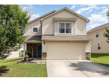 Charming two-story home features a two-car garage and manicured lawn at 4401 Lyman Ave, Raleigh, NC 27616