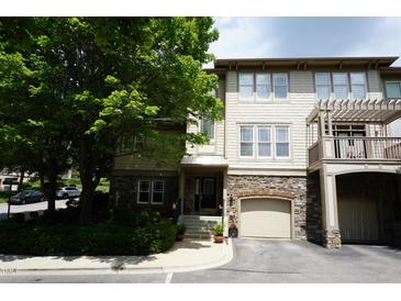 Inviting townhome exterior with stone accents, garage, and mature landscaping at 4810 Glenmist Ct, Raleigh, NC 27612