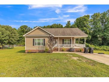 Charming single-story home with a welcoming front porch and well-maintained lawn and landscaping at 54 Lockwood Dr, Clayton, NC 27527