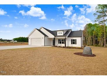 Charming single-story home with white siding, black accents, and an attached two-car garage at 80 Birchtop Cir, Zebulon, NC 27597