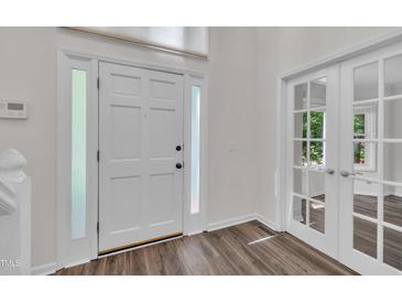Bright foyer featuring a white front door with sidelights and elegant french doors leading to another room at 100 Windvale Ct, Cary, NC 27518