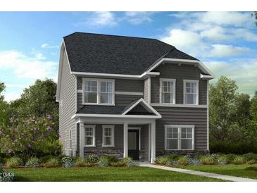 Beautiful two-story home showcasing a dark gray roof, gray siding, and white trimmed windows at 1057 Hardin Hill Ln, Knightdale, NC 27545