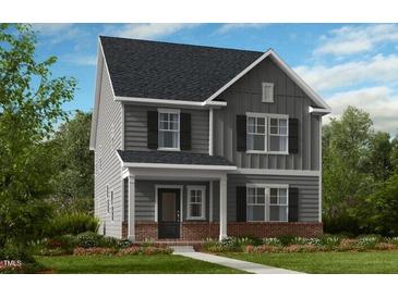 Charming two-story home with gray siding, black shutters, and a brick foundation at 1061 Hardin Hill Ln, Knightdale, NC 27545