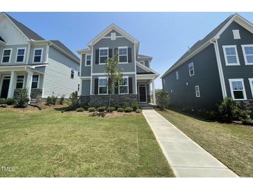 Charming two-story home featuring a stone facade and beautifully landscaped front yard at 1577 Goldfinch Perch Ln, Knightdale, NC 27545