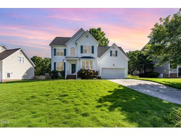 Charming two-story home with manicured lawn, attached garage, and inviting curb appeal under a lovely sunset at 1613 Patterson Grove Rd, Apex, NC 27502