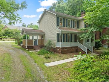 Charming two-story home with a welcoming front porch and beautiful green shutters at 20 Timberlyne Rd, Chapel Hill, NC 27514