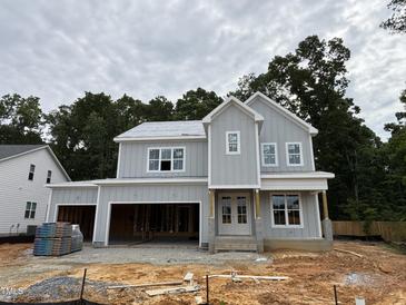 New construction home featuring light gray siding, white trim, and an attached two car garage at 3825 Fairway View Dr, Fuquay Varina, NC 27526