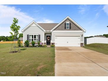 Charming single-Gathering home with a well-manicured lawn, two-car garage, and lovely front garden at 41 Liam Dr, Broadway, NC 27505