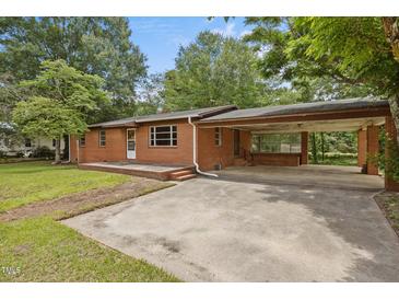 Brick ranch-style home with a covered carport and a spacious front yard, offering classic charm and functionality at 1051 Old Us 421, Lillington, NC 27546