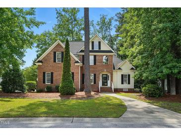 Charming two-story brick home with a manicured lawn, mature trees, and a welcoming front entrance at 3020 Woods Walk Way, Rocky Mount, NC 27804