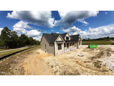New construction home with a black roof, tan siding, and stone accents, complemented by a spacious, sunny lot at 5008 Hopkins Chapel Rd, Zebulon, NC 27597