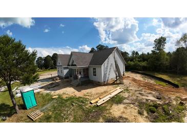 New construction featuring gray siding, a gray shingle roof, and a covered front porch at 5009 Hopkins Chapel Rd, Zebulon, NC 27597