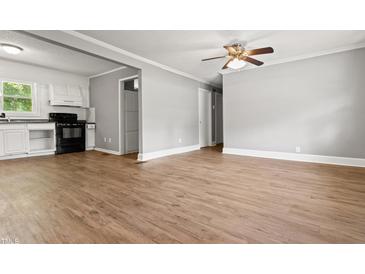 An open-concept living room and kitchen area with modern floors and updated appliances creates an inviting living space at 7924 Knightdale Blvd, Knightdale, NC 27545