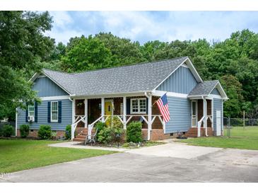 Charming home featuring blue siding, a welcoming front porch, and an American flag at 1008 Catsby Cir, Raleigh, NC 27603