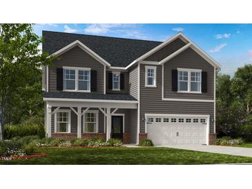 Charming two-story home with gray siding, black shutters, and a two-car garage at 1016 Dillon Lake Dr, Knightdale, NC 27545