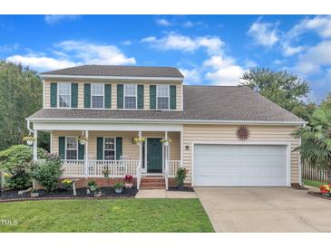 Charming two-story home with green shutters, a covered front porch, and a well-manicured lawn at 102 Lake Meadow Dr, Apex, NC 27502