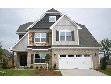 Charming two-story home featuring a brick facade, dark shutters, and a spacious two-car garage at 1042 Tulloch Court Ct # 213, Burlington, NC 27215