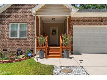 Charming brick home with covered front entrance, flower boxes, and a well-manicured lawn at 1051 Upland Reach, Sanford, NC 27332