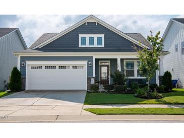 Beautiful home featuring a two-car garage, manicured lawn and professional landscaping at 1104 Briar Gate Dr, Holly Springs, NC 27540
