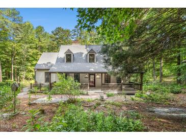 Charming home with a cozy front porch surrounded by lush greenery and trees, offering a peaceful retreat at 139 Trillium Pl, Chapel Hill, NC 27517
