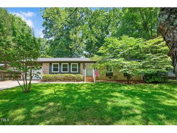 Charming brick home with a well-maintained lawn and lush greenery, offering great curb appeal at 202 Howland Ave, Cary, NC 27513