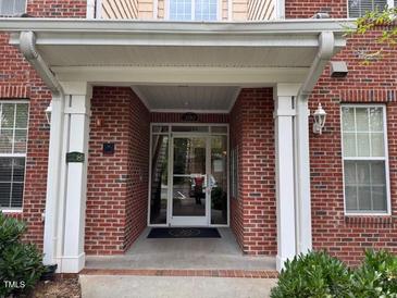 Covered doorway with white pillars and brick facade at Building 200 offers a welcoming entrance at 211 Providence Glen, Chapel Hill, NC 27514