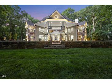 Stunning custom home featuring stone accents, a circular window, and manicured landscaping at 2207 Vintage Hill Dr, Durham, NC 27712