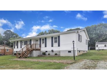 Charming one-story home with white siding, black shutters, and a wooden staircase leading to the front door at 2528 Barwick Dr, Durham, NC 27704