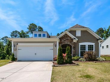 Charming single Gathering home with well-maintained landscaping, a two-car garage, and stone accents around the front door at 2609 Kilmartin Dr, Fuquay Varina, NC 27526