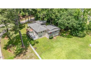 An aerial view of a charming house, showcasing its lush green lawn and a mature tree setting at 3012 Optimist Farm Rd, Apex, NC 27539