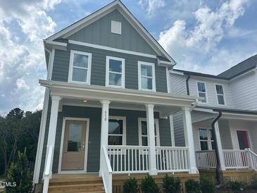 Charming two-story home with a covered front porch, white railing, and a well-manicured lawn at 510 Yeowell Dr, Chapel Hill, NC 27514