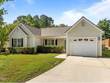 Charming single-story home featuring a well-manicured lawn, attached garage, and inviting front entrance at 608 Kinship Ln, Apex, NC 27502