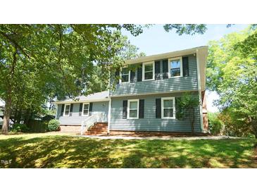 Charming two-story home with black shutters and brick accents, nestled under lush green trees at 8201 Blue Heron Way, Raleigh, NC 27615