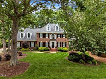 Charming brick home boasts lush lawn, manicured landscaping, and black shutters at 116 Berry Hill Dr, Raleigh, NC 27615