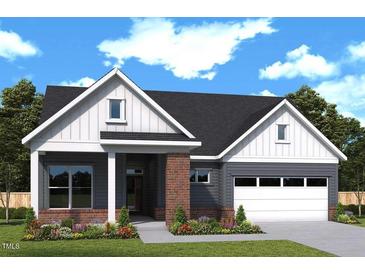 Charming single-story home featuring a two-car garage, brick accents, and beautifully landscaped front yard at 146 Aspen Ave, Pittsboro, NC 27312