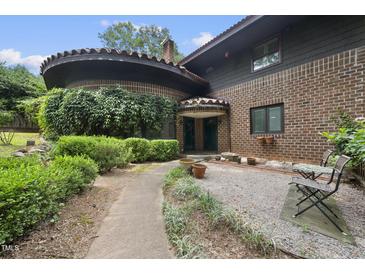 Unique brick home with beautiful landscaping and a curved entrance, offering curb appeal at 1705 Nottingham Rd, Raleigh, NC 27607