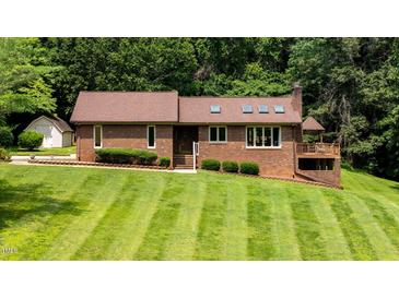 Charming brick home with a manicured lawn and mature trees providing a serene and private setting at 2523 Lovette Ln, Graham, NC 27253