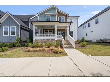 Charming two-story home with a welcoming front porch and beautifully landscaped front yard at 34 Millennium Dr, Pittsboro, NC 27312
