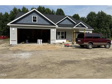 New construction home featuring blue and gray exterior, an attached garage, and professional landscaping at 4024 N Nc 581 Hwy, Kenly, NC 27542