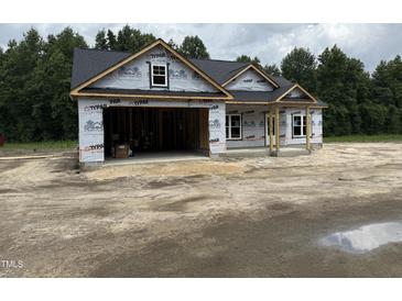 A new home under construction featuring an open two-car garage and a covered front porch at 4024 N Nc 581 Hwy, Kenly, NC 27542
