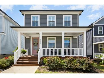 Charming two-story home with a welcoming front porch and a pink door at 513 Basin Hill Dr, Wake Forest, NC 27587