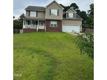 Charming two-story home with a manicured lawn, two car garage, and welcoming front porch at 642 Pinevalley Ln, Sanford, NC 27332