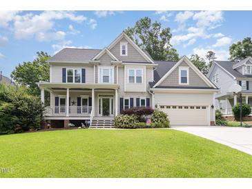 Charming two-story home with a front porch, attached two-car garage, and a well-manicured lawn at 105 Acorn Ridge Ln, Holly Springs, NC 27540