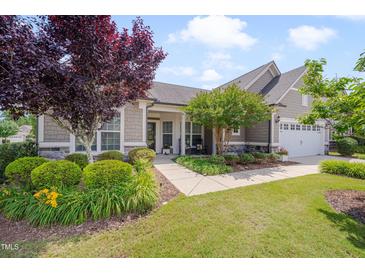 Charming single-Gathering home with well-manicured landscaping and inviting front porch with stone accents and a two car garage at 1120 Hooper Pl, Durham, NC 27703