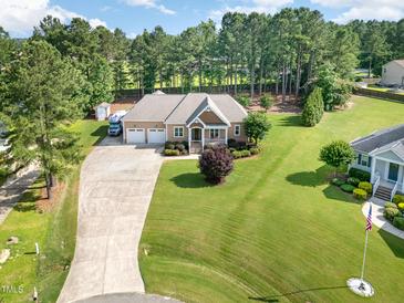 Expansive aerial view of a tan home featuring an attached garage and large, well-maintained lawn at 142 Crestline Dr, Selma, NC 27576