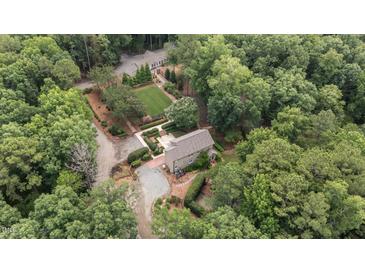 Beautiful home with manicured lawn surrounded by lush trees providing a private, estate-like setting at 2283 Mays Chapel Rd, Sanford, NC 27330