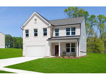 Stunning two-story home boasts a classic brick facade, attached garage, and well-manicured lawn under a clear blue sky at 242 Macon Lake Drive # 37, Apex, NC 27523