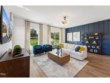 Bright living room with a modern chandelier, stylish furniture, and large windows offering scenic views at 2808 Kempthorne Rd # 61, Cary, NC 27519