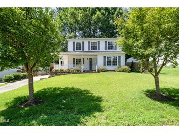 Charming two-story home featuring a well-manicured front lawn and classic white exterior with black shutters at 2817 Henslowe Dr, Raleigh, NC 27603