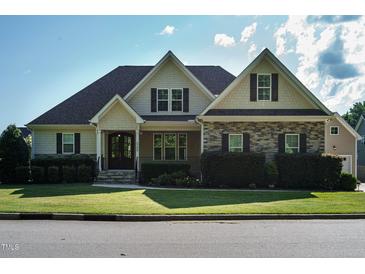 Charming home with a stone and siding exterior, manicured lawn, and welcoming front porch at 5305 Yorkville Ct, Holly Springs, NC 27540